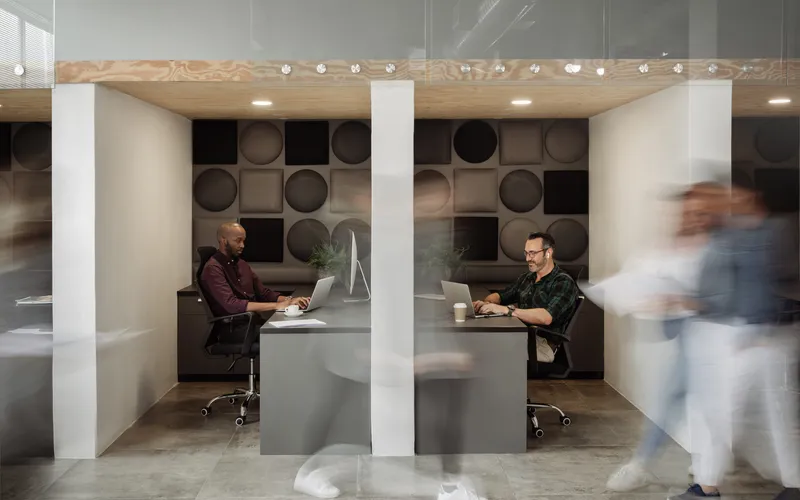 Menschen im modernen Workspace arbeiten an ihren Laptops