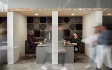 Menschen im modernen Workspace arbeiten an ihren Laptops
